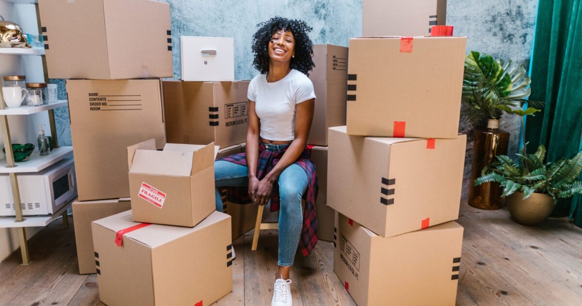 Woman sitting with labeled moving boxes ready for relocation and packing services
