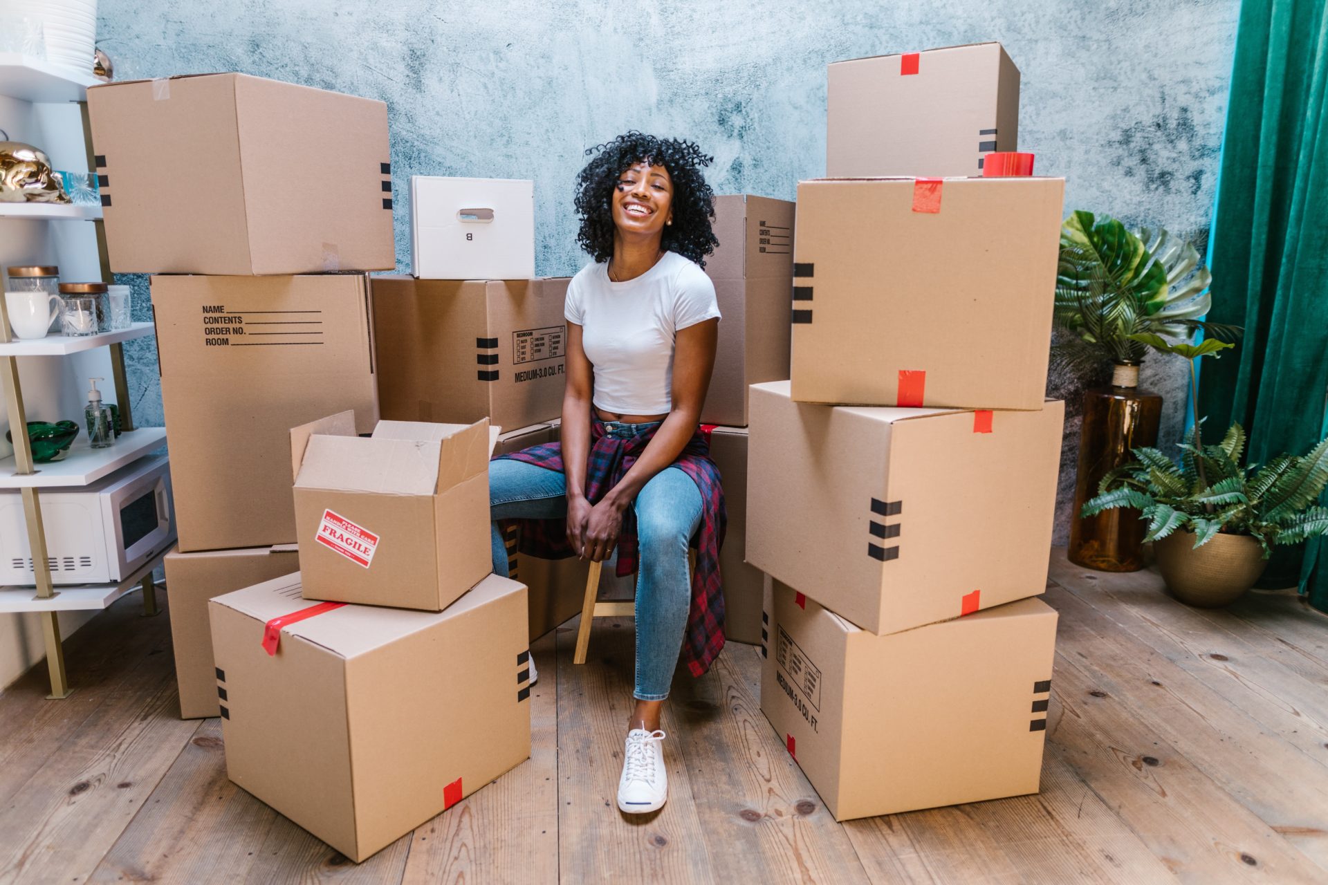 Woman sitting with labeled moving boxes ready for relocation and packing services